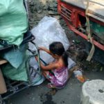 A little girl trying to diligently restring a discarded toy